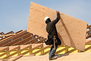 Worker building a home with plywood