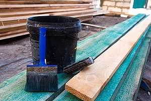 a bucket of primer that provides a layer between fire-treated wood