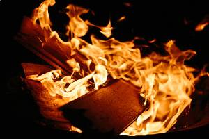 A plank of fire retardant plywood on a burning fire