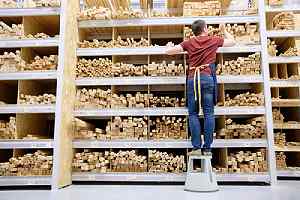 A worker arranging lumber in a storage facility of a wholesale lumber supplier