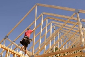 man building building roof with lumber