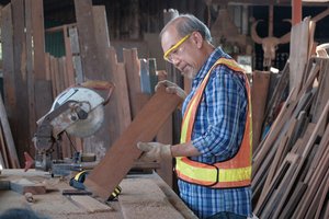 A male carpenter applying machine stress grading to a piece of lumber