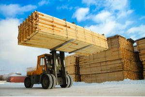 Forklift truck moving lumber to the godown
