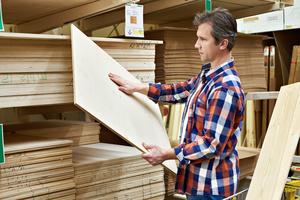 A man checking plywood stored in a godown