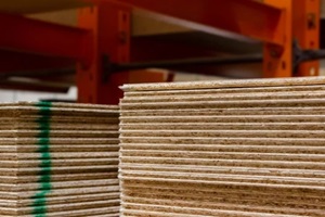 photo of treated wood panels stacked in construction supply store shelves
